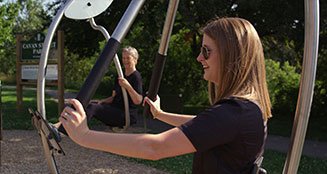 Woman using outdoor fitness equipment at Cavan Street Park